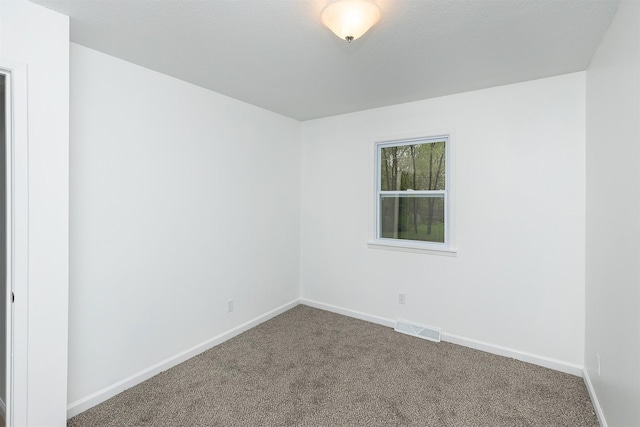 carpeted empty room featuring baseboards and visible vents