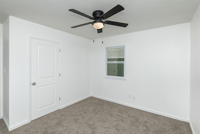 carpeted empty room with a ceiling fan and baseboards