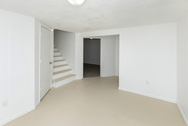 interior space featuring baseboards, stairs, and a textured ceiling