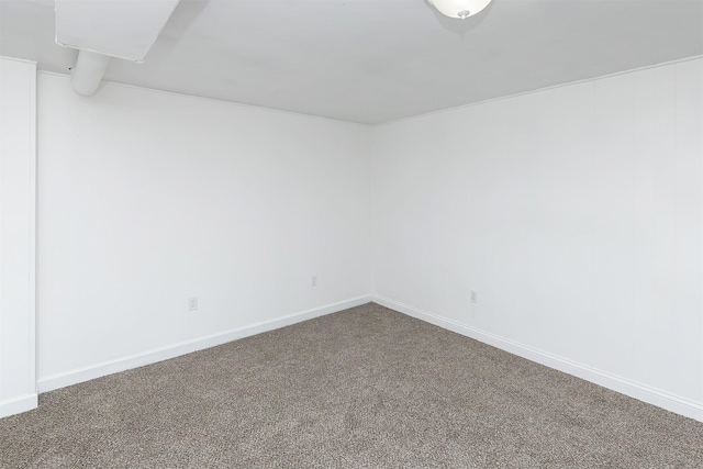 empty room featuring baseboards and carpet