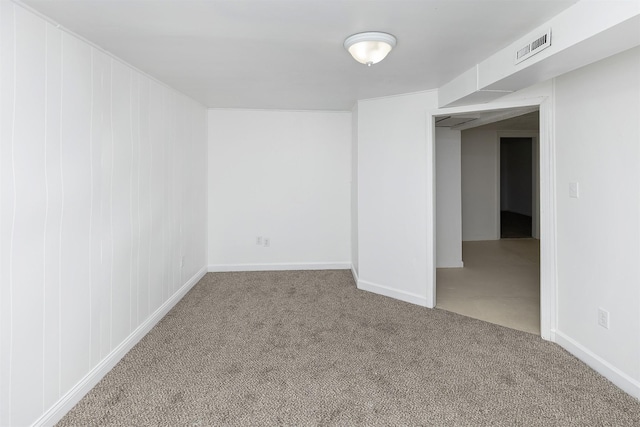spare room with carpet floors, baseboards, and visible vents