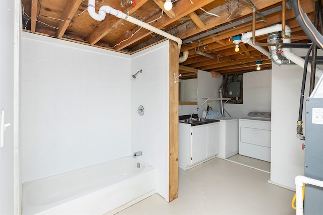 unfinished basement featuring a sink, independent washer and dryer, and electric panel