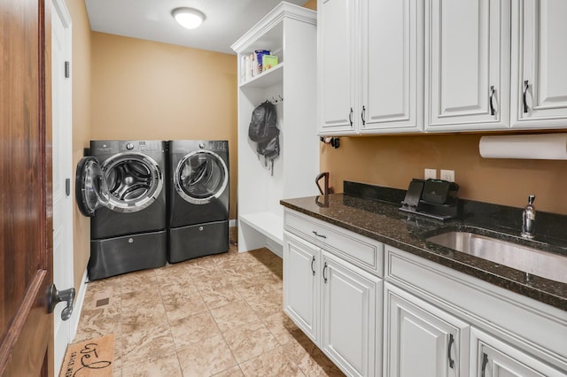 laundry area with a sink, washer and dryer, and cabinet space