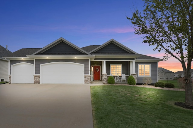 craftsman house featuring a lawn, covered porch, concrete driveway, and a garage
