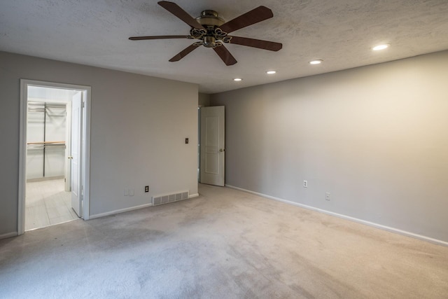 unfurnished bedroom with light colored carpet, visible vents, baseboards, recessed lighting, and a ceiling fan