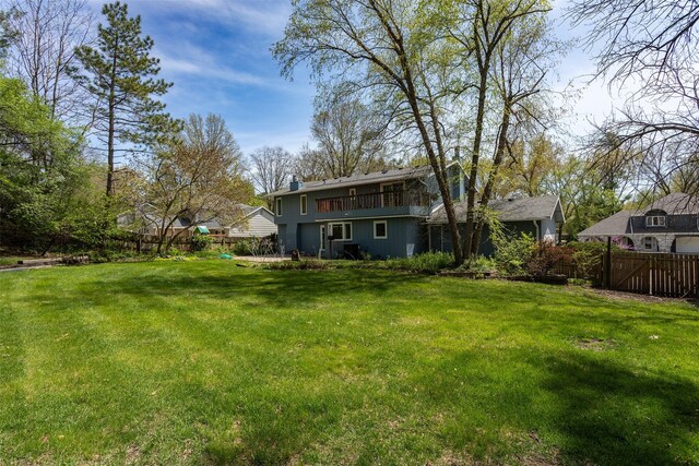 view of yard with a fenced backyard and a balcony