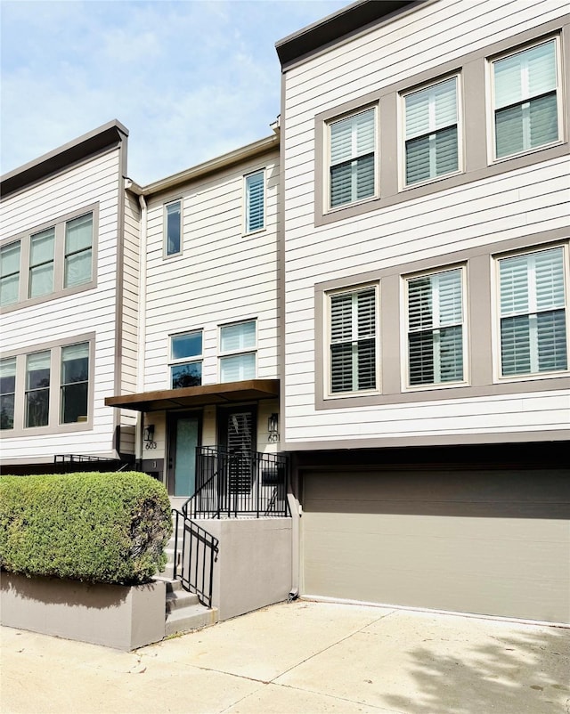 townhome / multi-family property with driveway and a garage