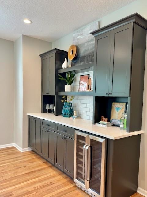 601 41st St, Des Moines, IA 50312 - indoor dry bar featuring wine cooler, light wood-style floors, a textured ceiling, and recessed lighting