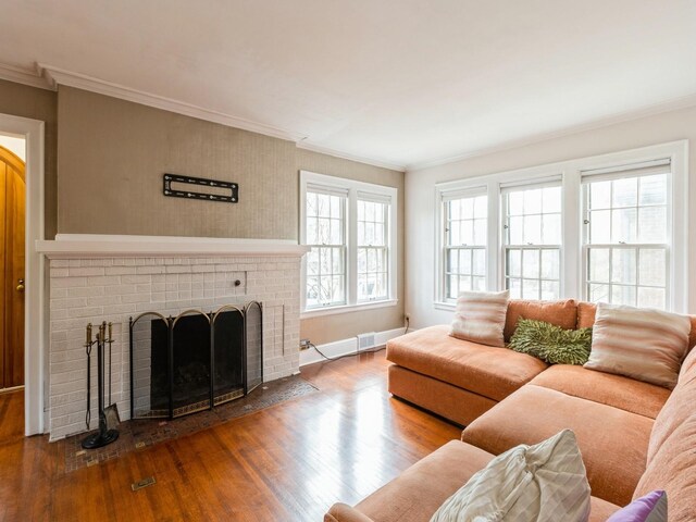 322 49th St, Des Moines, IA 50312 - living area with wood finished floors, crown molding, a brick fireplace, baseboards, and arched walkways