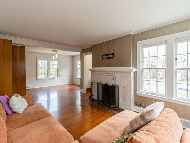 322 49th St, Des Moines, IA 50312 - living room featuring wood finished floors, a fireplace, ornamental molding, and baseboards