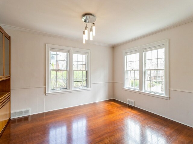 322 49th St, Des Moines, IA 50312 - empty room with wood finished floors, crown molding, and a wainscoted wall