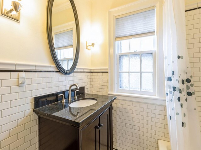 322 49th St, Des Moines, IA 50312 - full bathroom featuring tile walls, a wainscoted wall, and vanity