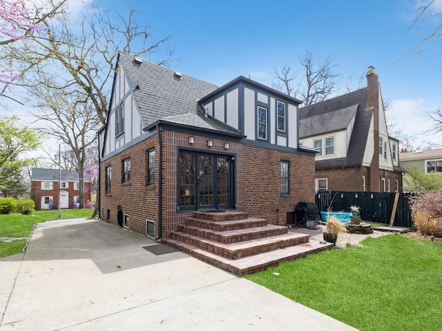 322 49th St, Des Moines, IA 50312 - rear view of house featuring brick siding, roof with shingles, and a chimney