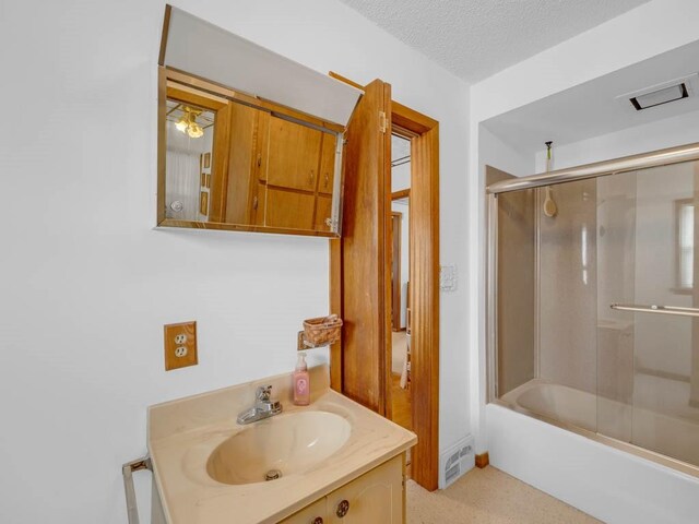 1313 Rose Ave, Des Moines, IA 50315 - full bath with vanity, enclosed tub / shower combo, a textured ceiling, and visible vents