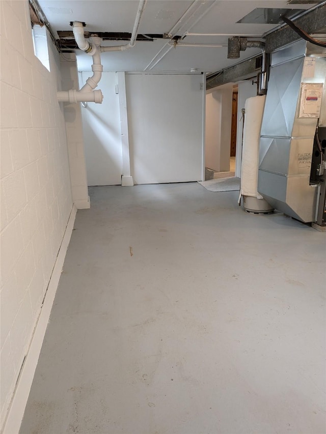 1300 NE 50th Pl, Des Moines, IA 50313 - basement featuring heating unit, concrete block wall, water heater, and fridge