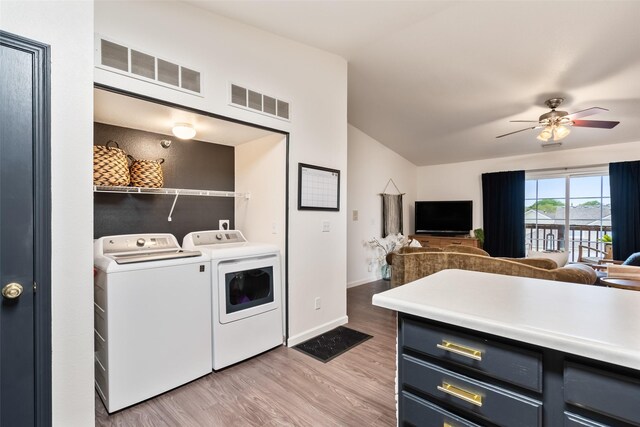 laundry area with visible vents, wood finished floors, washing machine and clothes dryer, and laundry area