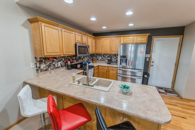 kitchen featuring light countertops, a peninsula, backsplash, and stainless steel appliances