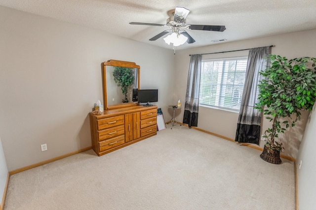 office space featuring visible vents, a ceiling fan, baseboards, and light carpet