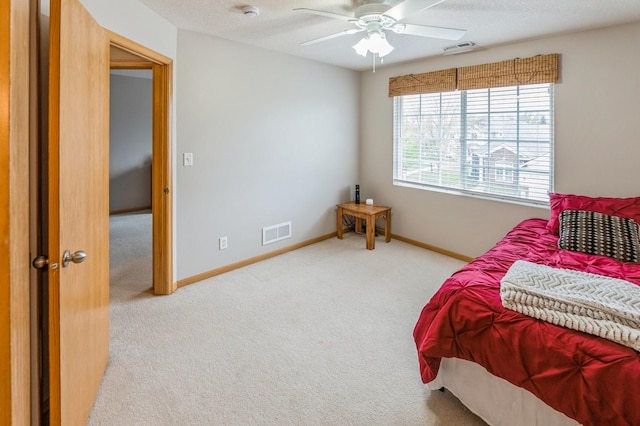 carpeted bedroom featuring visible vents, baseboards, and ceiling fan