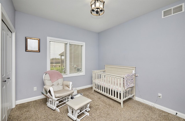 carpeted bedroom featuring visible vents, baseboards, a notable chandelier, and a closet