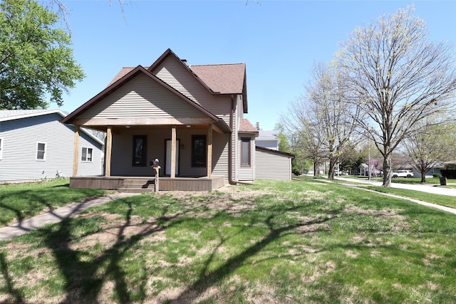 view of front of house featuring a shingled roof, a front lawn, and covered porch