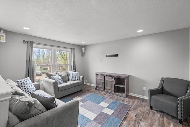 living room with recessed lighting, a textured ceiling, and wood finished floors