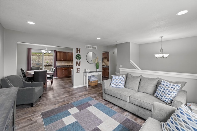 living area with an inviting chandelier, recessed lighting, dark wood finished floors, and visible vents