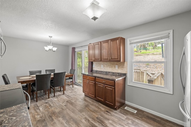 kitchen with freestanding refrigerator, a textured ceiling, and wood finished floors