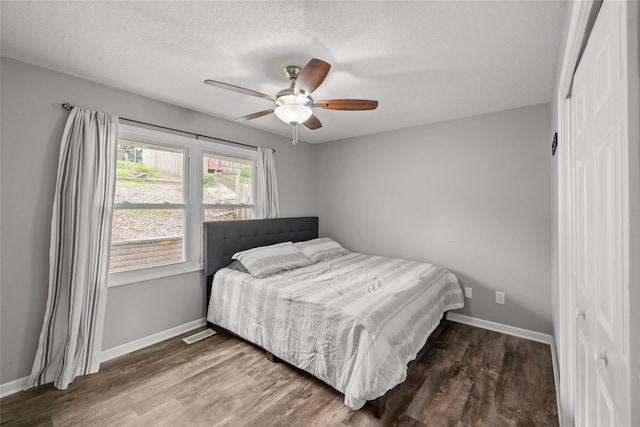 bedroom featuring baseboards, wood finished floors, and visible vents