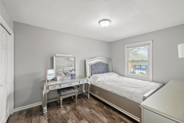 bedroom featuring a textured ceiling, baseboards, a closet, and wood finished floors