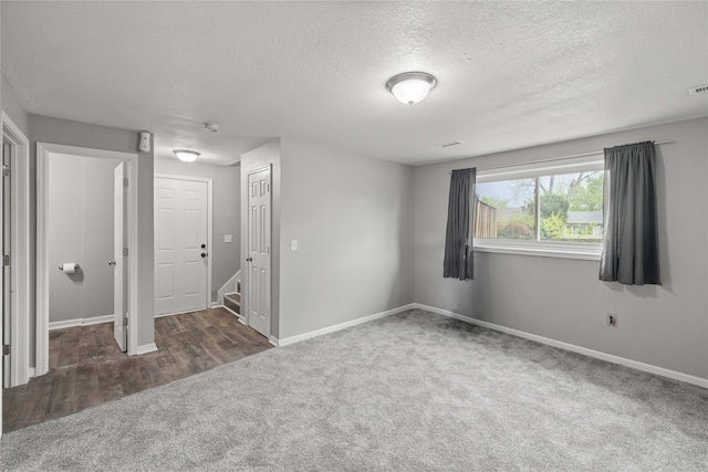 unfurnished bedroom featuring carpet flooring, a textured ceiling, and baseboards