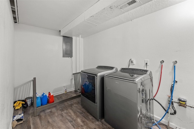 clothes washing area with laundry area, electric panel, visible vents, wood finished floors, and washer and clothes dryer