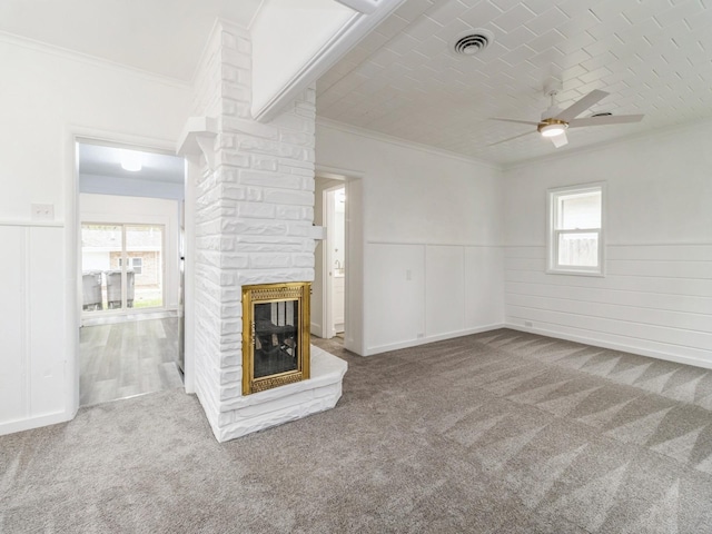 unfurnished living room with carpet flooring, ceiling fan, visible vents, and ornamental molding