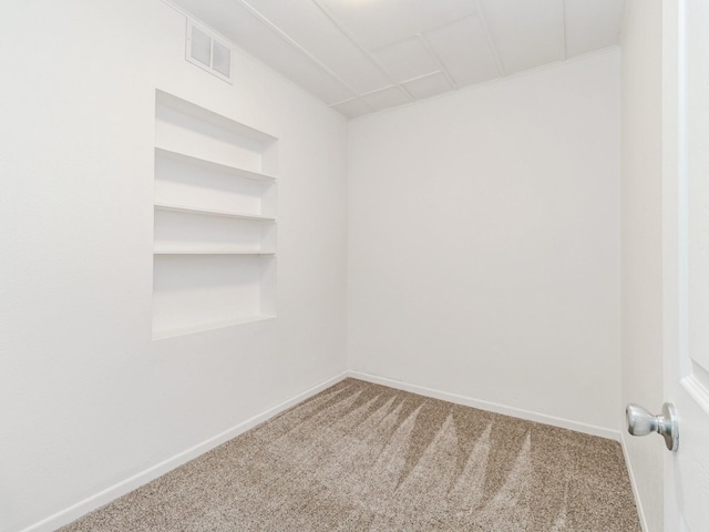empty room with carpet flooring, baseboards, and visible vents