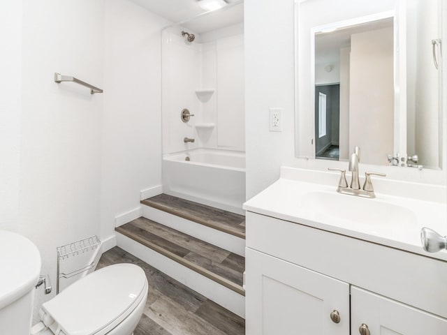 bathroom featuring toilet, tub / shower combination, wood finished floors, and vanity