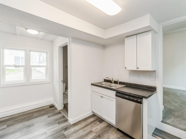 kitchen with a sink, dishwasher, white cabinets, and dark countertops