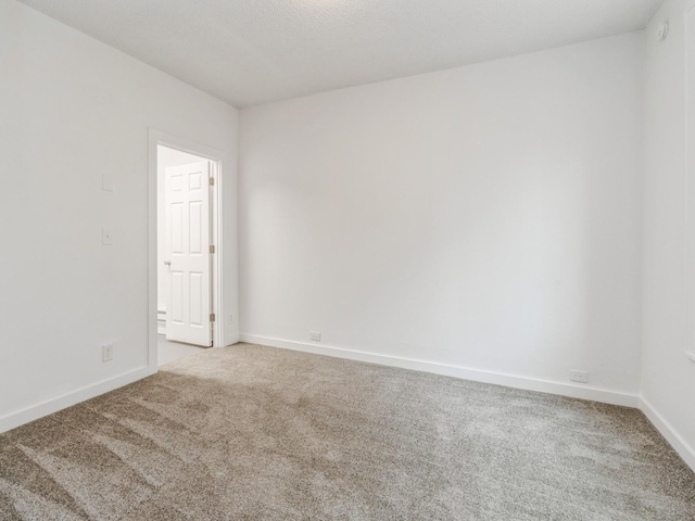 carpeted spare room with baseboards