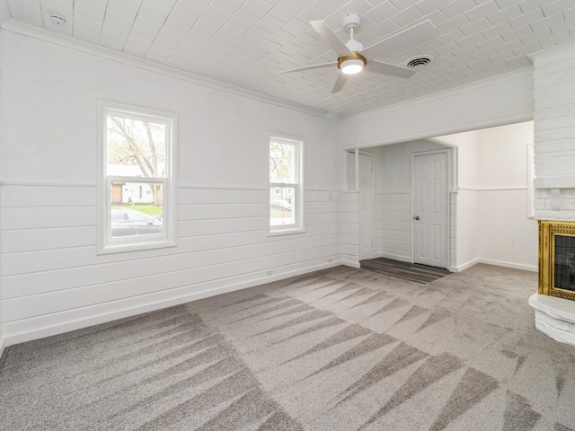 unfurnished living room featuring plenty of natural light, ornamental molding, carpet, and visible vents