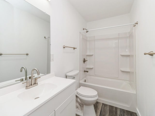 full bath with vanity, wood finished floors, toilet, and shower / washtub combination