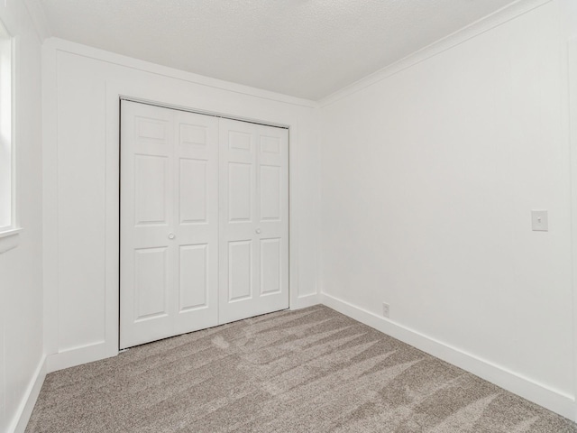 unfurnished bedroom featuring a closet, baseboards, and carpet flooring