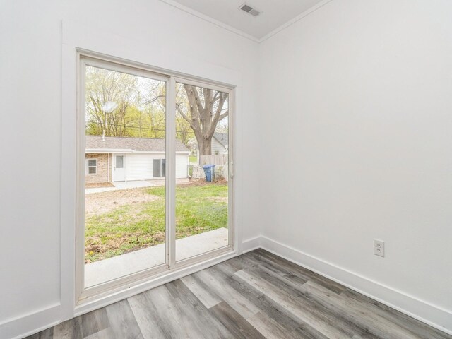 4040 6th Ave, Des Moines, IA 50313 - empty room featuring wood finished floors, baseboards, and crown molding