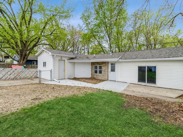 rear view of house featuring fence, roof with shingles, a gate, a patio, and a yard