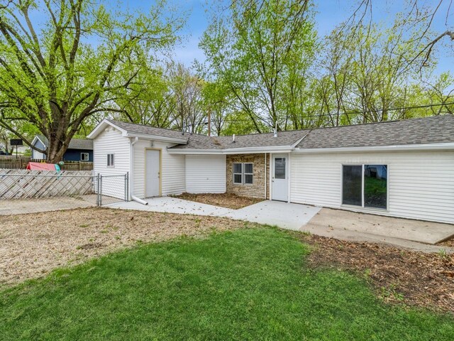 4040 6th Ave, Des Moines, IA 50313 - back of house featuring a patio, a gate, a shingled roof, and stone siding
