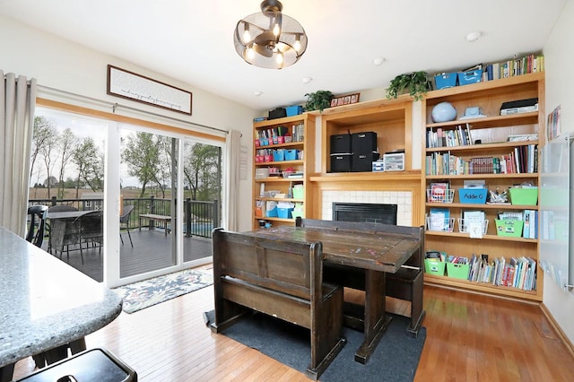 office featuring a notable chandelier, hardwood / wood-style floors, and a tile fireplace