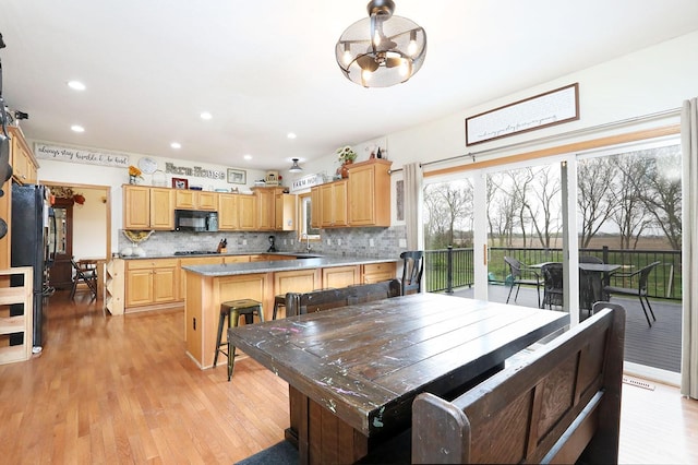 dining area with light wood-style floors and recessed lighting