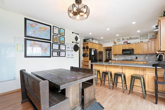 dining space featuring recessed lighting, an inviting chandelier, and light wood finished floors