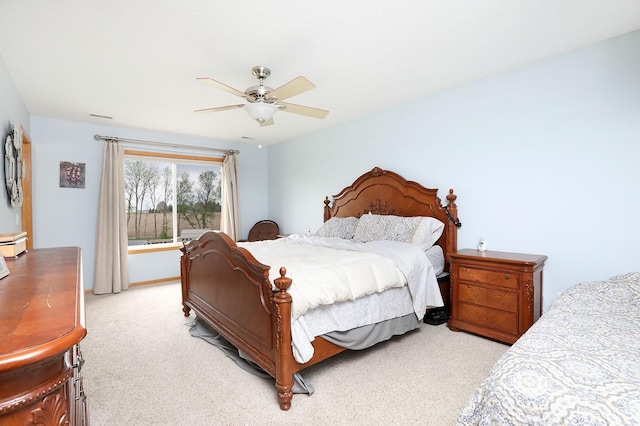 bedroom featuring a baseboard heating unit, ceiling fan, and light colored carpet
