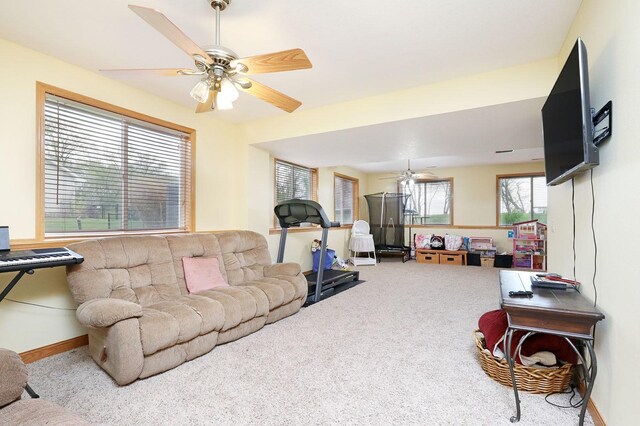 carpeted living room with baseboards and a ceiling fan