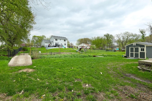 view of yard with fence, an outbuilding, and a shed