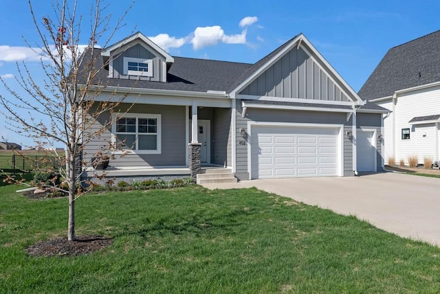 craftsman-style house featuring board and batten siding, driveway, a front yard, and a garage